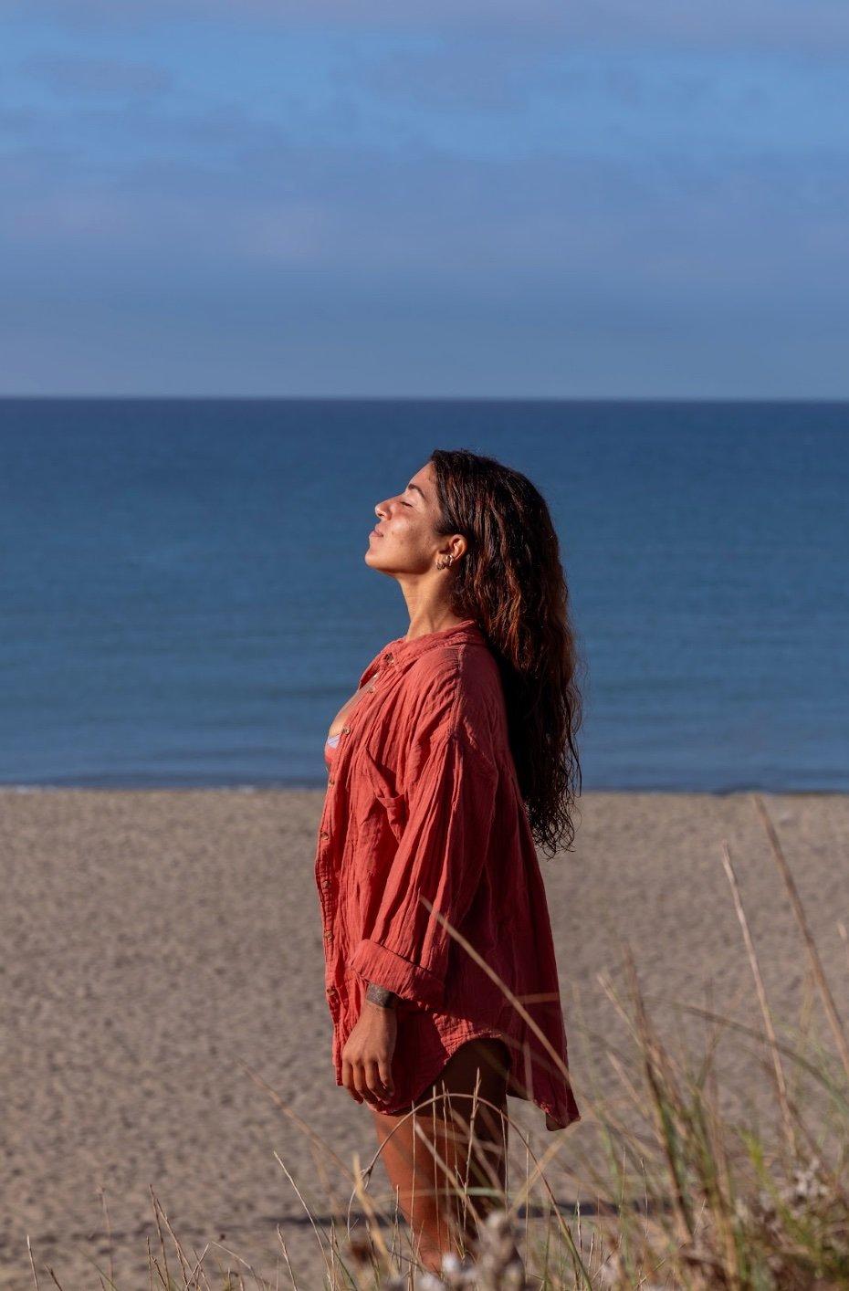 Anna in profilo, sguardo verso il cielo, mare sullo sfondo