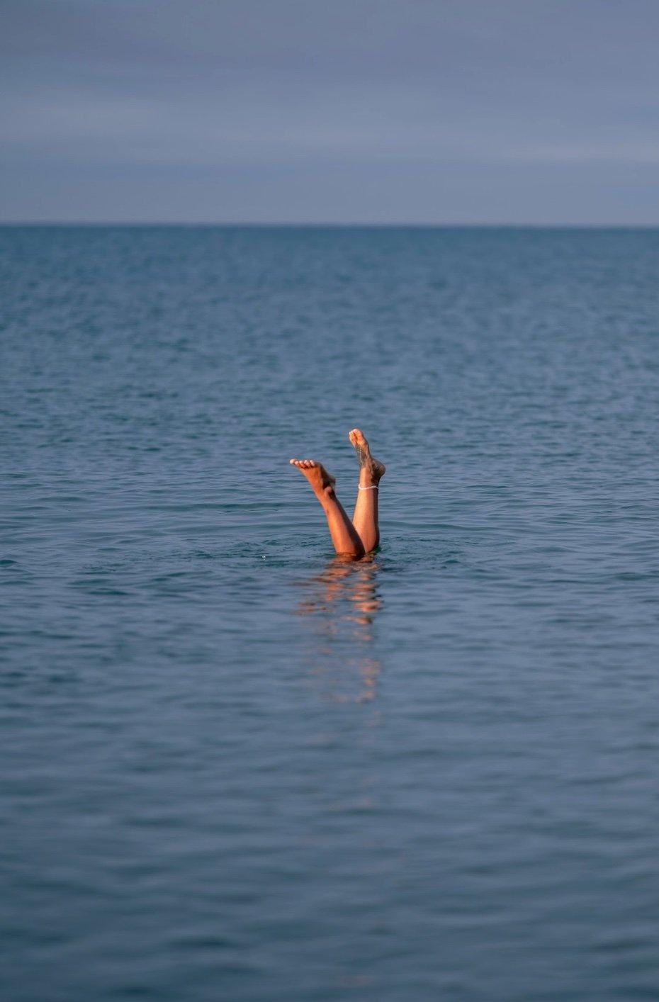 Gambe che spuntano dall'acqua del mare